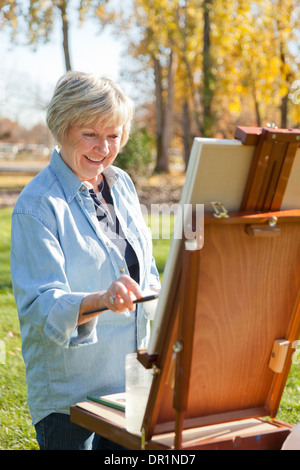 Ältere Frau, die Malerei im freien Stockfoto