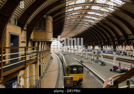 Innenansicht der trainshed mit Eisen & Glas dach, stationäre Züge & Menschen warten auf platfom - Der Bahnhof York, North Yorkshire, England, UK. Stockfoto