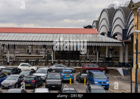 Blick von außen Plattformen, Veranda, Passagiere zu Fuß und gebogene Fenster der Viktorianischen trainshed - Der Bahnhof York, North Yorkshire, England, UK. Stockfoto