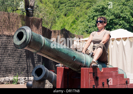 Happy Tourist Frau sitzen auf alte Kanone in Gibraltar. Stockfoto