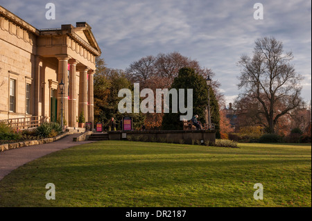 Menschen, die von beeindruckenden Yorkshire Museum, in einer schönen, ruhigen Parklandschaft entspannen, in frühen Abend Sonnenlicht gebadet - Museum Gardens, York, England, UK. Stockfoto