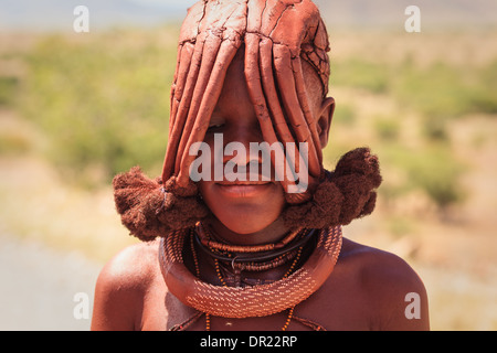 Porträt einer Himba-Frau, die in Damaraland, Namibia, einen schicken Stammes-Kopfschmuck trägt Stockfoto