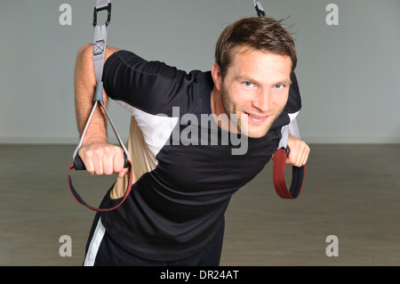 Ein Mann nutzt Aussetzung Ringe Stockfoto