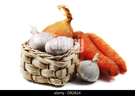 Knoblauch in einen kleinen Weidenkorb, Karotten und Zwiebeln auf einem weißen Hintergrund Stockfoto