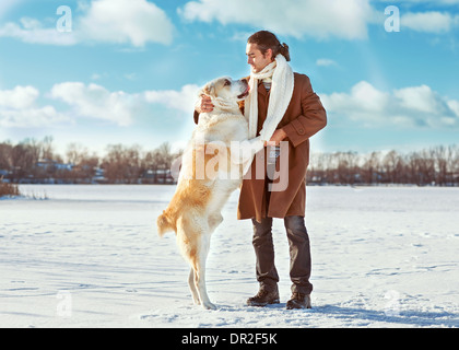 Mann und zentralasiatischen shepherd spielen mit seinem Hund im freien Stockfoto