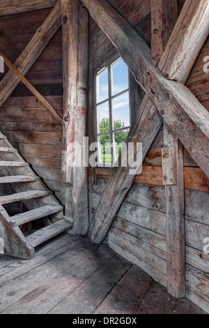 Innenraum eines verlassenen Holzhaus mit Treppe und Blick auf den grünen Garten. Stockfoto