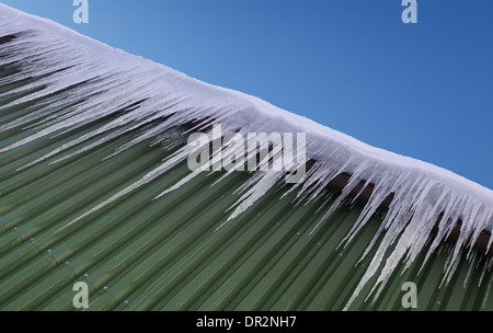 Riesige Eiszapfen hängen vom Dach Stockfoto