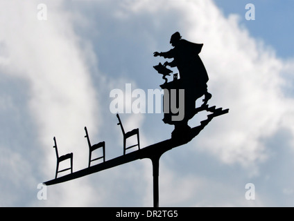 Ungewöhnliche Wetterfahne - Prediger im Gespräch mit leeren Kirchenbänken - Silhouette gegen den Himmel - weiße Wolken und blauer Himmel - Sonnenlicht Stockfoto