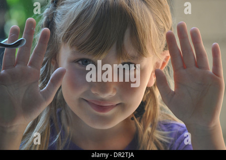 Close-up Portrait von glücklichen Mädchen drückte gegen ein Fenster mit Blick Stockfoto