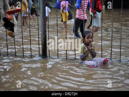 Jakarta, Indonesien. 18. Januar 2014. Eine Mädchen zittert im Hochwasser in Jakarta, Indonesien, 18. Januar 2014. Weit verbreitet Überschwemmungen in der indonesischen Hauptstadt Jakarta sieben Toten und Vertriebenen verlassen hat, die etwa 11.000 Menschen mit größeren Überschwemmungen voraussichtlich in den nächsten zwei Tagen durch die heftigen Regenfälle verursacht werden, sagte Sutopo Purwo Nugroho, der Sprecher für nationale Katastrophe Agentur Xinhua telefonisch am Samstag. Bildnachweis: Agung Kuncahya B./Xinhua/Alamy Live-Nachrichten Stockfoto