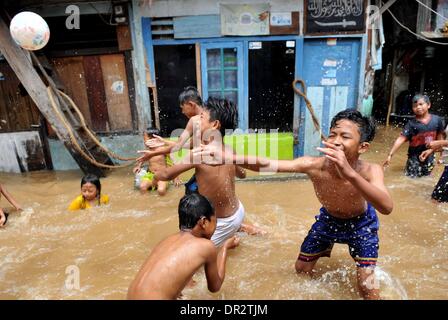 Jakarta, Indonesien. 18. Januar 2014. Kinder spielen einen Ball in Flut Wasser in Jakarta, Indonesien, 18. Januar 2014. Weit verbreitet Überschwemmungen in der indonesischen Hauptstadt Jakarta sieben Toten und Vertriebenen verlassen hat, die etwa 11.000 Menschen mit größeren Überschwemmungen voraussichtlich in den nächsten zwei Tagen durch die heftigen Regenfälle verursacht werden, sagte Sutopo Purwo Nugroho, der Sprecher für nationale Katastrophe Agentur Xinhua telefonisch am Samstag. Bildnachweis: Agung Kuncahya B./Xinhua/Alamy Live-Nachrichten Stockfoto