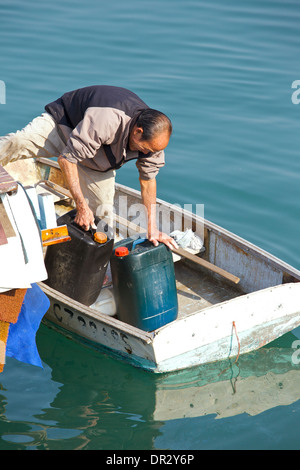 Chinesischer Mann arbeitet auf seinem Beiboot in der Causeway Bay Typhoon Shelter, Hong Kong. Stockfoto