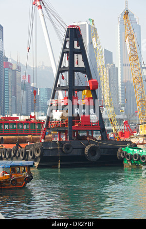 Derrick Barge am Bau des zentralen Wan Chai Bypass in der Causeway Bay Typhoon Shelter, Hong Kong Skyline hinter sich. Stockfoto