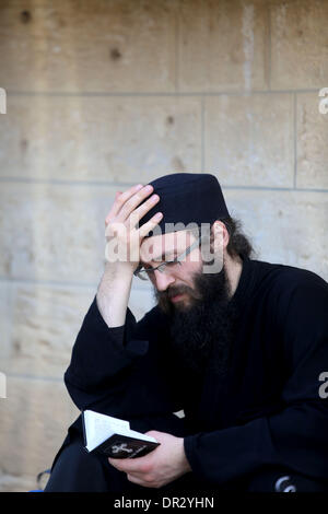 Jericho. 18. Januar 2014. Griechische orthodoxe Priester liest Bibel während der Taufzeremonie am Standort als Qasr el-Yahud am Ufer des Jordan River in der Nähe von der Westbank-Stadt Jericho, 18. Januar 2014 bekannt. Orthodoxe Christen strömten zum Jordan, das Fest der Erscheinung des Herrn am traditionellen Standort zu feiern, wo es geglaubt wird, dass der Täufer Jesus Christus getauft. Bildnachweis: Fadi Aruri/Xinhua/Alamy Live-Nachrichten Stockfoto