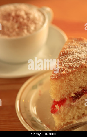 Kuchen und Kaffee Cappuccino mit einer Scheibe von Marmelade und Sahne Biskuit gefüllt Stockfoto