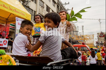 Metro Manila, Philippinen - 18. Januar 2014: Kinder spielen mit den Bildern des Kindes Jesus beim Lakbayaw Festival, "Lakbayaw" Festival aus dem Tagalog Wörter, "Lakbay" (Reise) und "Sayaw" (Tanz) in das Stadtgebiet von Tondo, Manila, die fast alle Organisationen, Schulen, Gruppen und Menschen in Tondo als Bestandteil ihrer Hingabe an Santo Nino.The Philippinen vereint ist die einzige römisch-katholische Nation in Südost-Asien mit rund 93 Prozent des Glaubens zu üben. Bildnachweis: Herman Lumanog/Alamy Live-Nachrichten Stockfoto