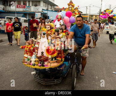 Metro Manila, Philippinen - 18. Januar 2014: ein Anhänger tragen Bilder von Jesuskind in ein Dreirad während Lakbayaw Festival, "Lakbayaw" aus dem Tagalog Wörter, "Lakbay" (Reise) und "Sayaw" (Tanz) in das Stadtgebiet von Tondo, Manila, die fast alle Organisationen, Schulen, Gruppen und Menschen in Tondo als Bestandteil ihrer Hingabe an Santo Nino.The Philippinen vereint ist die einzige römisch-katholische Nation in Südost-Asien mit rund 93 Prozent des Glaubens zu üben. Bildnachweis: Herman Lumanog/Alamy Live-Nachrichten Stockfoto