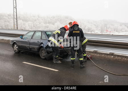 Feuerwehrmänner helfen bei einem Autounfall auf der Brücke über die Weichsel im Winter, Plock Polen Stockfoto