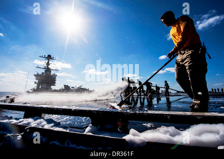 Matrosen reinigen das Flugdeck des Flugzeugträgers USS Harry S. Truman Stockfoto