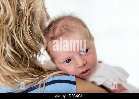 Babymädchen auf die Schulter Mutter Stockfoto