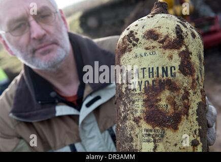 Stockstadt, Deutschland. 18. Januar 2014. Initiator Uwe Benkel hält ein Sauerstoffgerät während der Wiederherstellung ein US-Kampfflugzeug aus dem zweiten Weltkrieg durch ein Team von Freiwilligen und Reservisten der Bundeswehr auf einem Feld in der Nähe von Stockstadt, Deutschland, 18. Januar 2014. Das p-47 "Thunderbolt" Flugzeug stürzte dieses in das Feld aus großer Höhe im Frühjahr 1945. Experten glauben der Pilot bei dem Absturz gestorben zu sein. Foto: BORIS ROESSLER/Dpa/Alamy Live News Stockfoto