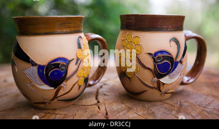 Zwei dekorative und einzigartige handgefertigte Kaffeebecher mit stark verzierten und bunten Motiven der australischen Flora und fauna Stockfoto