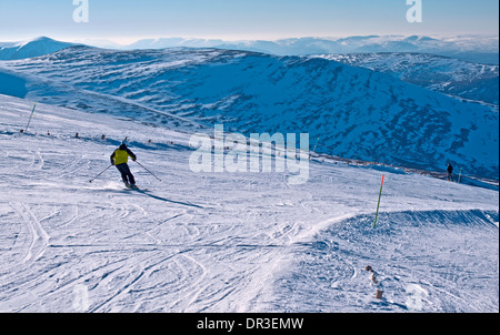 Ein Skifahrer auf Skiabfahrt, Cairngorm Mountain Ski Centre in der Nähe von Aviemore, schöner sonniger Tag, Cairngorms, Schottland Stockfoto