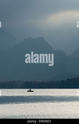 Blick nach Süden, entlang Derwent Water, sind 2 Silhouetten auf einem Boot vor einen herrlichen Borrowdale Hintergrund Angeln. Stockfoto