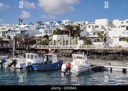 Typische weiße Ferienwohnungen direkt am Wasser mit Blick auf den Hafen von Puerto del Carmen, Lanzarote, Kanarische Inseln, Spanien Stockfoto