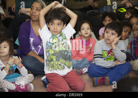 Kinder, Lehrer & Eltern singen gemeinsam jeden Montagmorgen in der Burg Brücke öffentlichen Elementary School in Manhattan, NYC Stockfoto