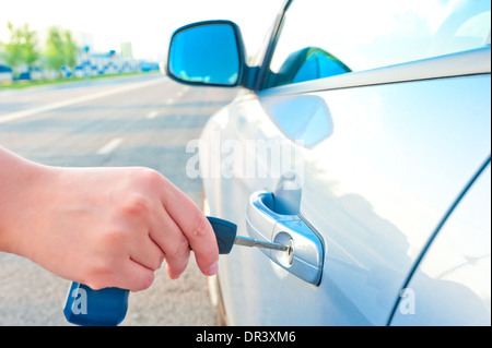 Frau öffnet einen Haustürschlüssel eines Neuwagens Stockfoto