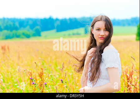 junge schöne Frau mit langen Haaren in weiß in Farben Stockfoto
