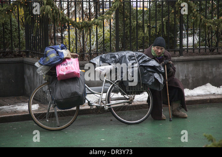 Alte Frau macht ihren Weg bis Broadway mit all ihren Besitz auf ihrem Fahrrad in New York City. Stockfoto