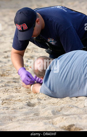 Ein EMT setzen Status tags auf ein Opfer verletzt an einem Strand in einem mass Casualty Vorfall Wisconsin Stockfoto