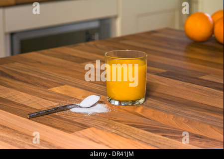 Orangensaft und Zucker, große Mengen an Zucker in Fruchtsäften. Stockfoto