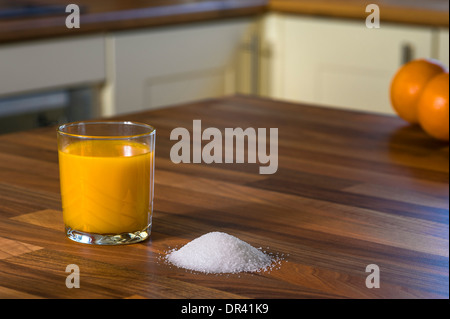 Orangensaft und Zucker, große Mengen an Zucker in Fruchtsäften. Stockfoto