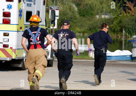 Drei Feuerwehr-Sanitäter laufen für den Notfall Stockfoto