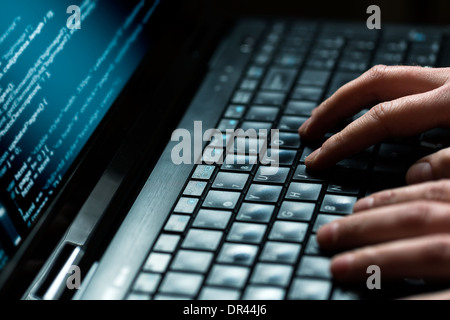 Hacker mit Laptop. Es gibt viele Ziffern auf dem Computerbildschirm. Stockfoto