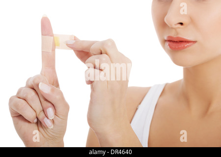 Schöne Frau setzt Klebeband an ihrem Finger. Auf weißem Hintergrund. Stockfoto