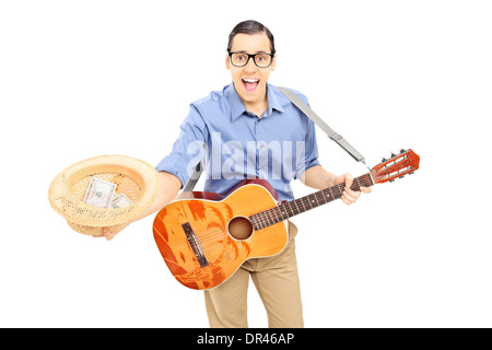 Junge männliche Straßenkünstler mit Gitarre sammeln Geld in seinen Hut Stockfoto