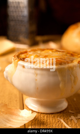 Französische Zwiebelsuppe mit geriebenem Käse und ein rundes Laib Brot Stockfoto