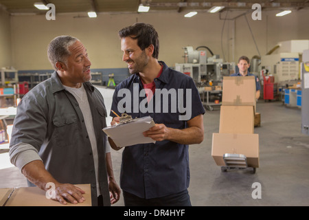 Arbeiter im Lager sprechen Stockfoto