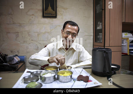 4. März 2009 - genießt Mumbai, Maharashtra, Indien - ein zufriedener Kunde für die letzten 20 Jahre glücklich sein zu Hause gekochtes Mittagessen, geschickt von seiner Frau in sein Büro, das von der Dabbawalla geliefert wurde.  Er spürt, dass die Dabbawalla System ihm hilft, nahrhafteste Essen zu genießen, die sonst nicht möglich angesichts der Logistikaufwand gewesen wäre. (Kredit-Bild: © Subhash Sha Stockfoto