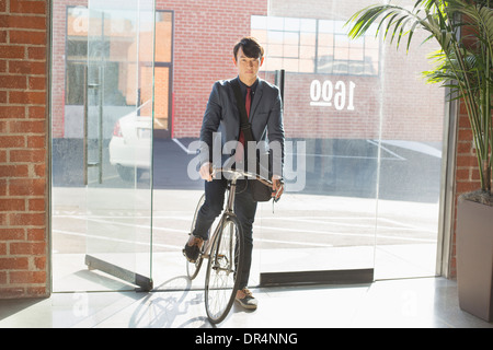 Koreanischer Geschäftsmann Machenschaften Fahrrad im Büro Stockfoto