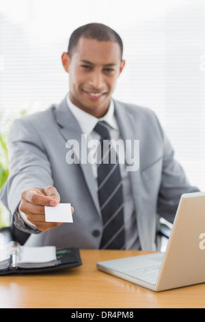 Gut gekleideter Mann reichte seine Visitenkarte am Schreibtisch Stockfoto