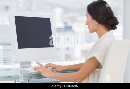 Junge Geschäftsfrau mit Computer im Büro Stockfoto