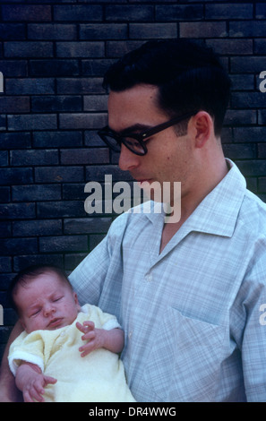 Junger europäische Mann wiegen sein junges Baby Sohn zwei Wochen alt in Blantyre, Malawi im Jahr 1969. Stockfoto