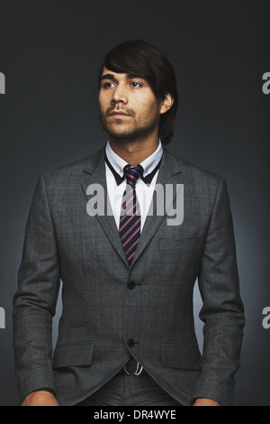 Porträt von hübscher Junge Business executive wegsehen. Gemischte Rassen Geschäftsmann im Anzug isolierten auf schwarzen Hintergrund. Stockfoto