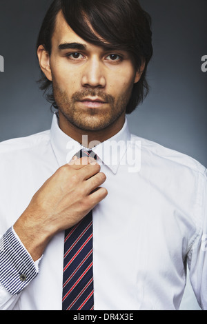 Closeup Portrait junger Mann in der formalen Kleidung anpassen seine Krawatte. Gut aussehend Business executive tragen Krawatte Stockfoto