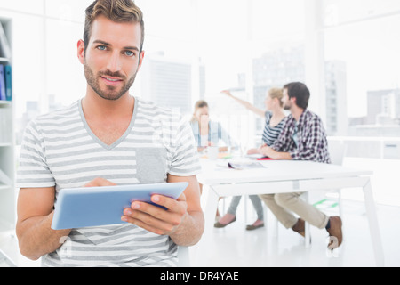 Mann mit digital-Tablette mit Kollegen im Hintergrund Stockfoto